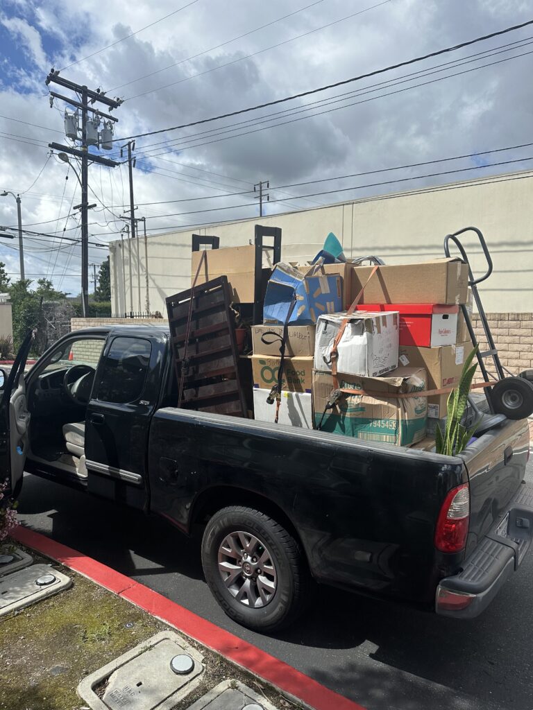 Household items loaded into a pickup truck and strapped down.