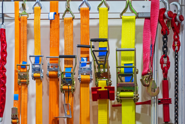 Various different ratchet straps hanging on a rack