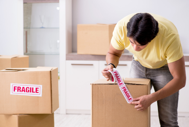 a man placing a fragile sticker on a moving box