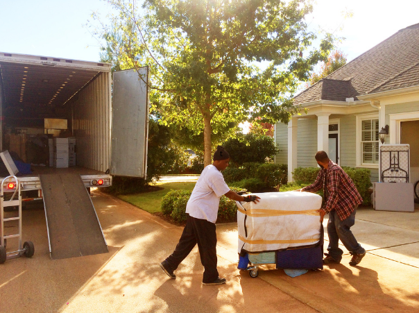 two men moving large items on a furniture dolly