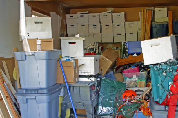 Cluttered garage with staked bins, boxes, and loose gear-before professional organization service.